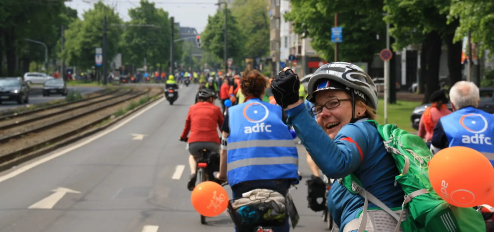 Frau auf Fahrrad bei Sternfahrt in Düsseldorf reckt die Faust
